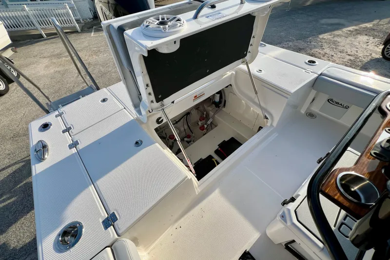 Slide: The Image of 2026 Robalo 246 Cayman boat interior with open storage compartment and visible equipment. - 13