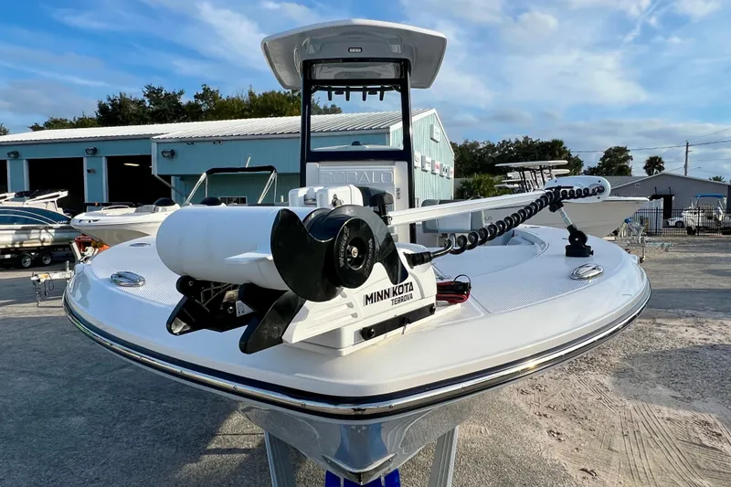 Slide: The Image of 2026 Robalo 246 Cayman boat with Minn Kota trolling motor, docked outdoors. - 3