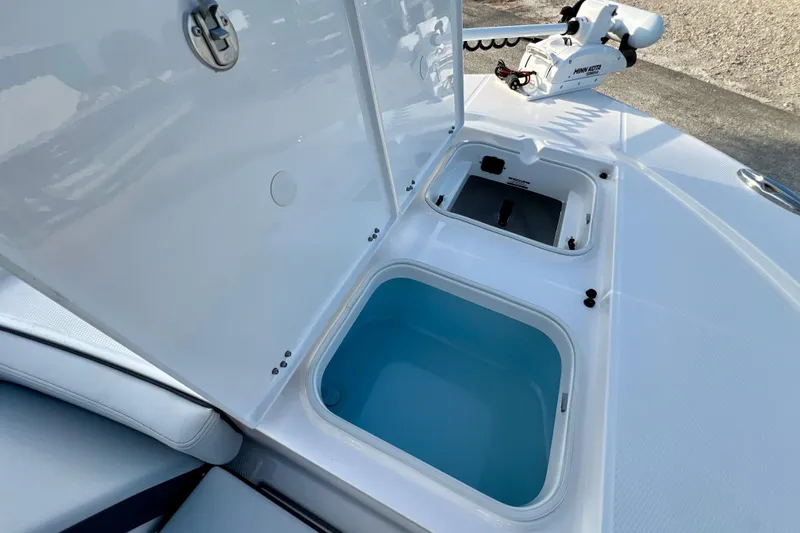 Slide: The Image of 2026 Robalo 246 Cayman boat storage compartments with open lids and trolling motor. - 30