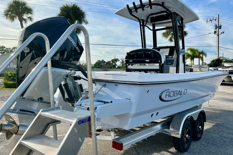 Slide: The Image of 2026 Robalo 246 Cayman boat on trailer with Mercury engine, parked outdoors. - 8