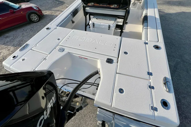 Slide: The Image of 2026 Robalo 246 Cayman boat deck with storage compartments and Mercury engine. - 9