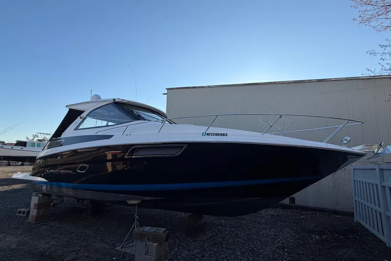 Slide: The Image of 2013 Regal 35 Sport Coupe boat on dry dock, side view, clear sky background. - 14