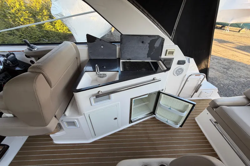 Slide: The Image of Interior of a 2013 Regal 35 Sport Coupe featuring a kitchenette with sink and mini-fridge. - 24