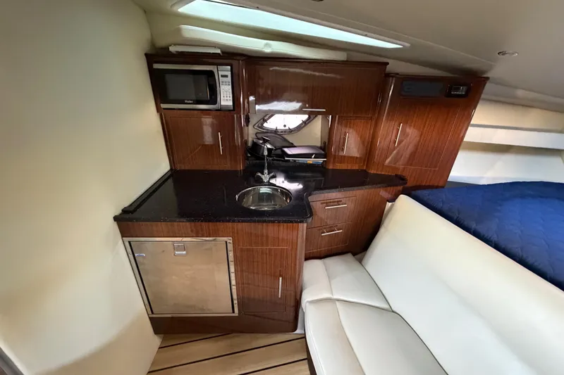 Slide: The Image of Compact kitchen area in a 2013 Regal 35 Sport Coupe yacht with modern amenities. - 32