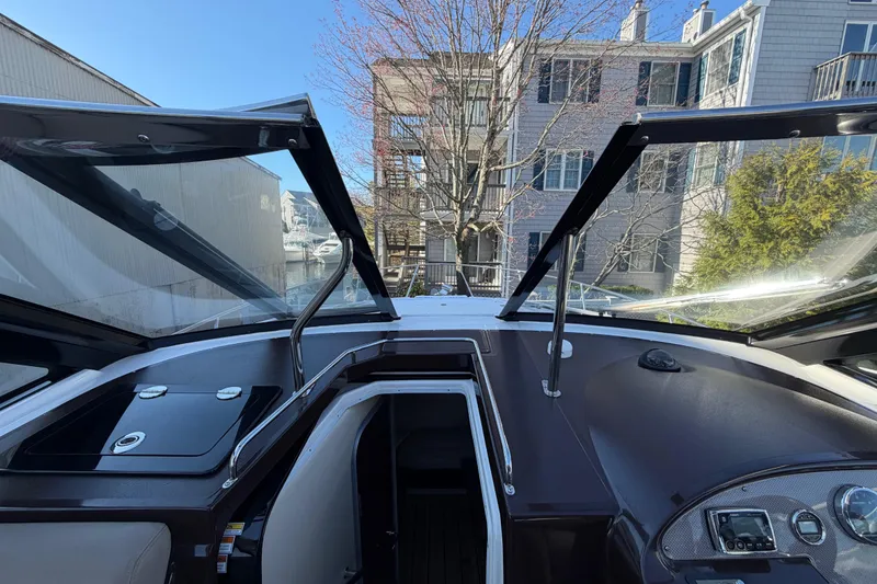 Slide: The Image of 2013 Regal 35 Sport Coupe cockpit with open sunroof, docked near residential buildings. - 39