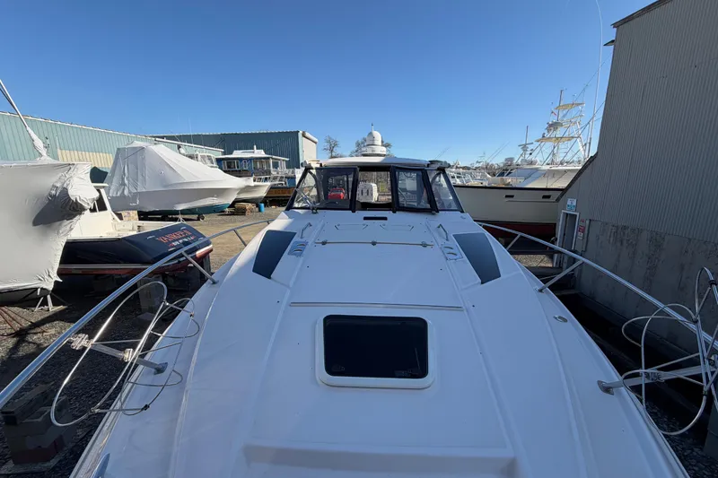 Slide: The Image of 2013 Regal 35 Sport Coupe yacht docked in a marina, surrounded by other boats. - 43