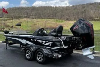 Slide: The Image of 2023 Nitro Z21 XL boat with powerful engine, parked outdoors on a paved surface. - 7