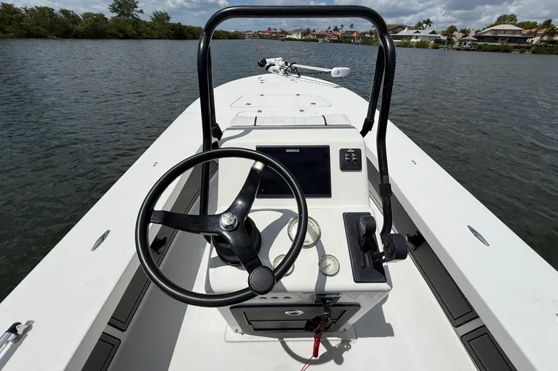 Slide: The Image of 2017 Beavertail Skiffs Lightning boat console with steering wheel and navigation system on water. - 10