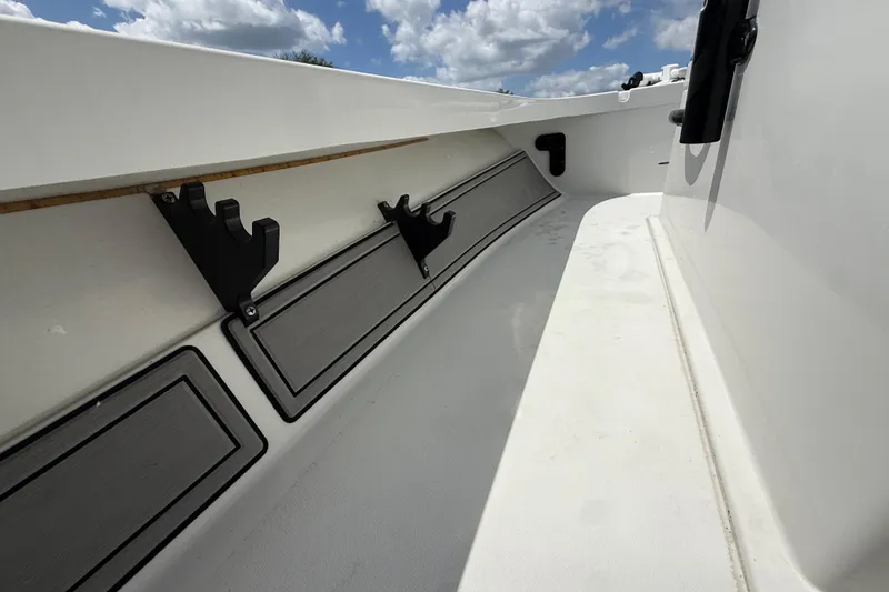 Slide: The Image of 2017 Beavertail Skiffs Lightning interior with rod holders and storage compartments under a blue sky. - 16