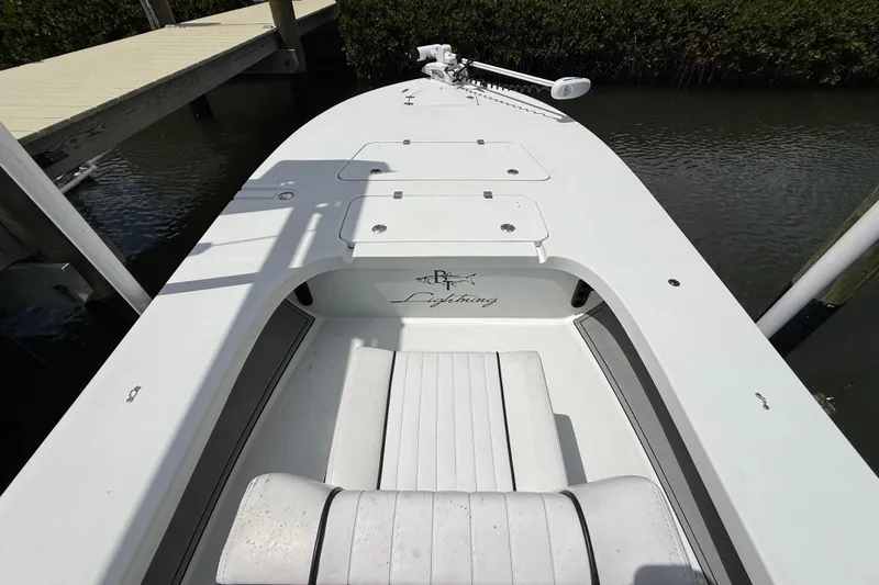 Slide: The Image of 2017 Beavertail Skiffs Lightning boat docked, showcasing sleek design and spacious deck. - 18