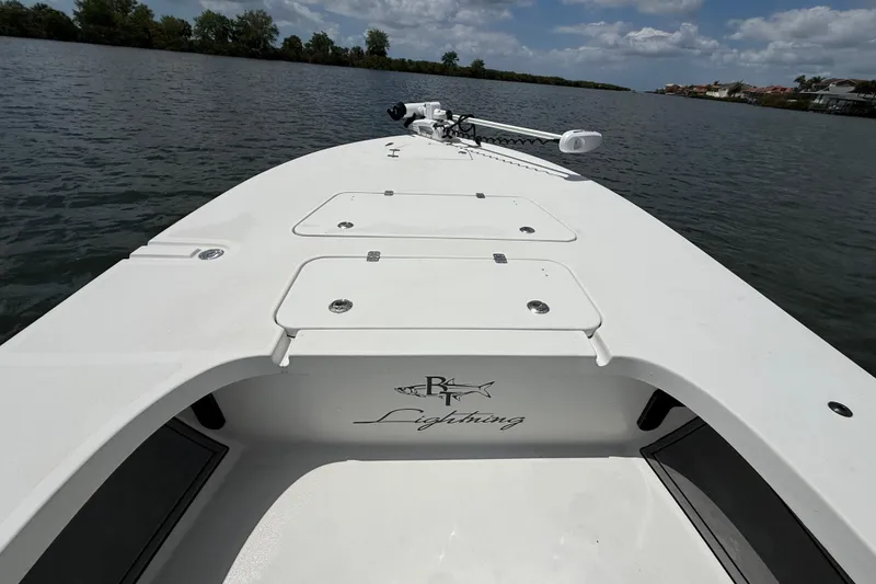 Slide: The Image of 2017 Beavertail Skiffs Lightning boat on calm water under a partly cloudy sky. - 19