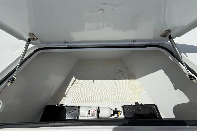 Slide: The Image of Open storage compartment of 2017 Beavertail Skiffs Lightning with fire extinguisher inside. - 23