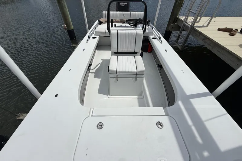 Slide: The Image of 2017 Beavertail Skiffs Lightning boat docked, featuring white seating and spacious deck. - 28