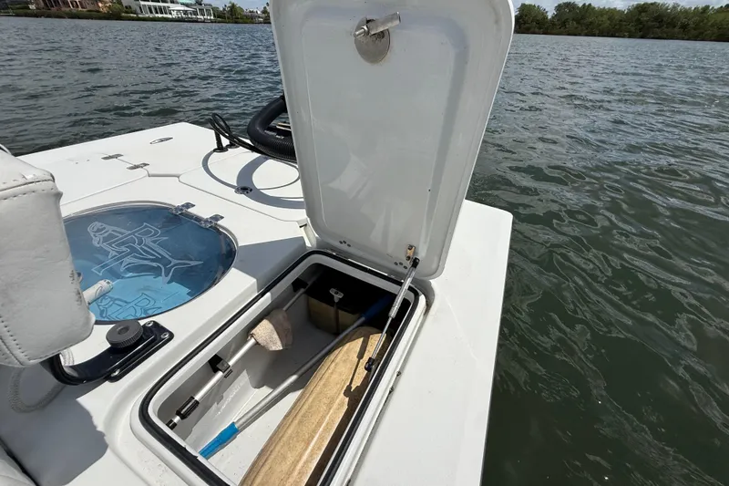 Slide: The Image of 2017 Beavertail Skiffs Lightning boat with open storage compartment on a calm lake. - 37