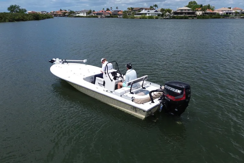 Slide: The Image of 2017 Beavertail Skiffs Lightning boat on calm water, featuring Evinrude outboard motor. - 4