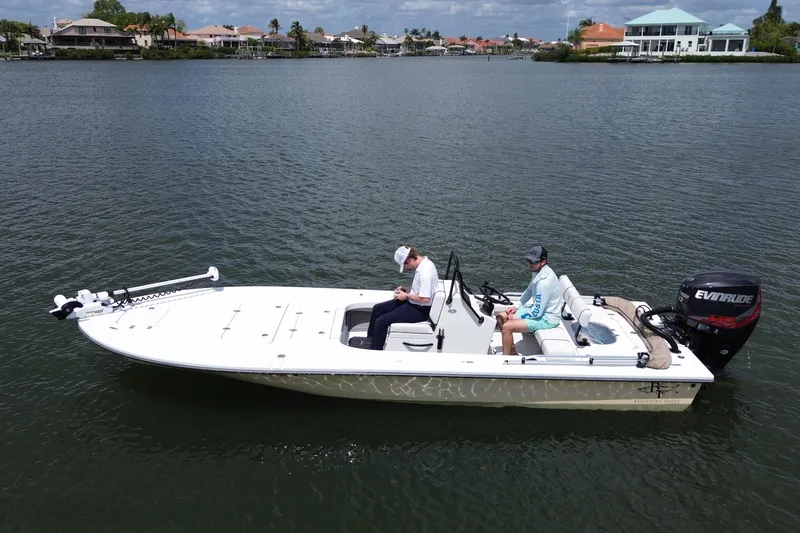 Slide: The Image of 2017 Beavertail Skiffs Lightning boat on calm water, two people seated, Evinrude motor visible. - 5