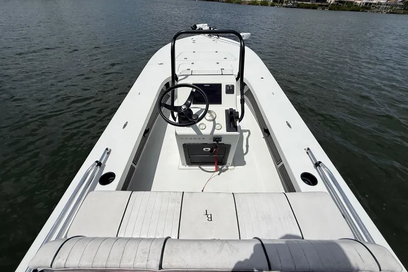 Slide: The Image of 2017 Beavertail Skiffs Lightning boat on water, featuring sleek design and central console. - 9
