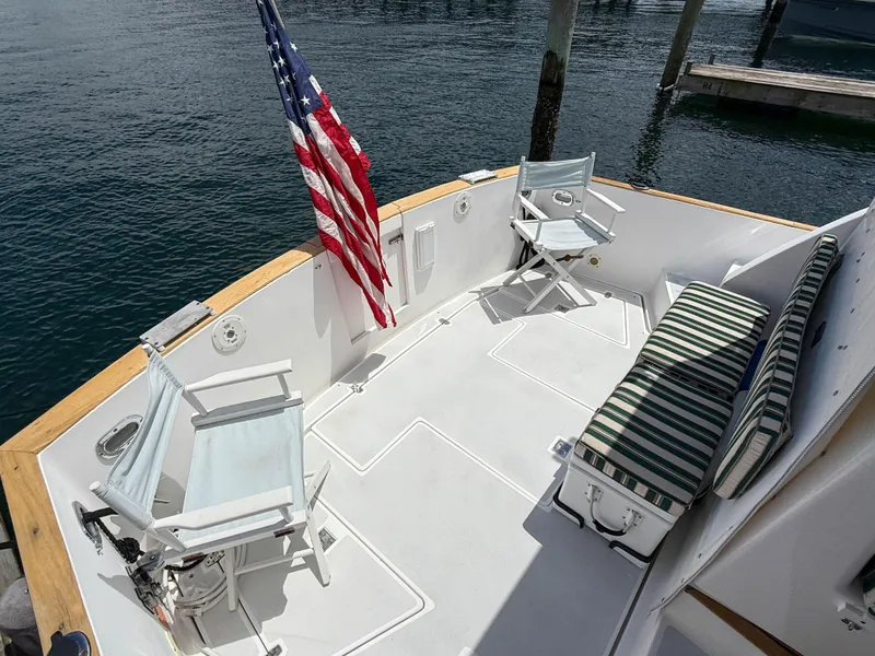 Slide: The Image of 2002 Legacy 34 Express boat deck with chairs, striped cushion, and American flag. - 10