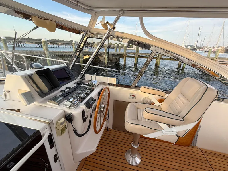 Slide: The Image of Helm of 2002 Legacy 34 Express boat with modern controls and waterfront view. - 19