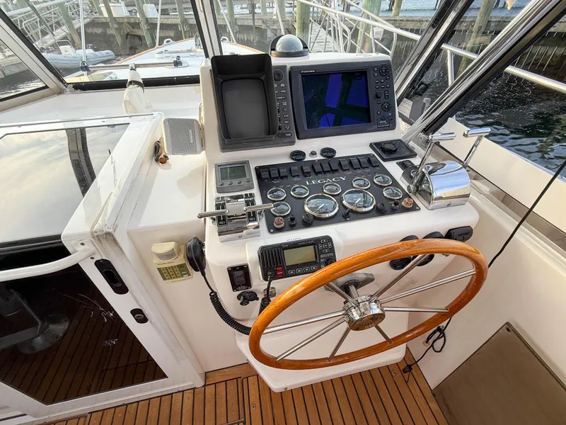Slide: The Image of Helm of 2002 Legacy 34 Express boat with navigation instruments and wooden steering wheel. - 20