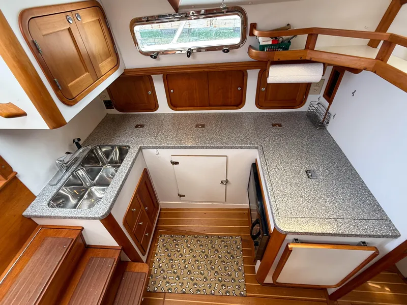 Slide: The Image of 2002 Legacy 34 Express boat kitchen with wooden cabinets and granite countertops. - 26