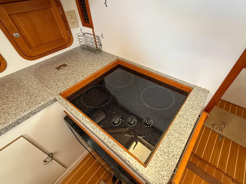 Slide: The Image of 2002 Legacy 34 Express yacht kitchen with electric stovetop and granite countertop. - 28