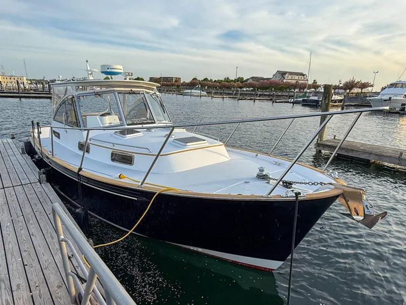 Slide: The Image of 2002 Legacy 34 Express boat docked at a marina, with calm water and clear skies. - 3