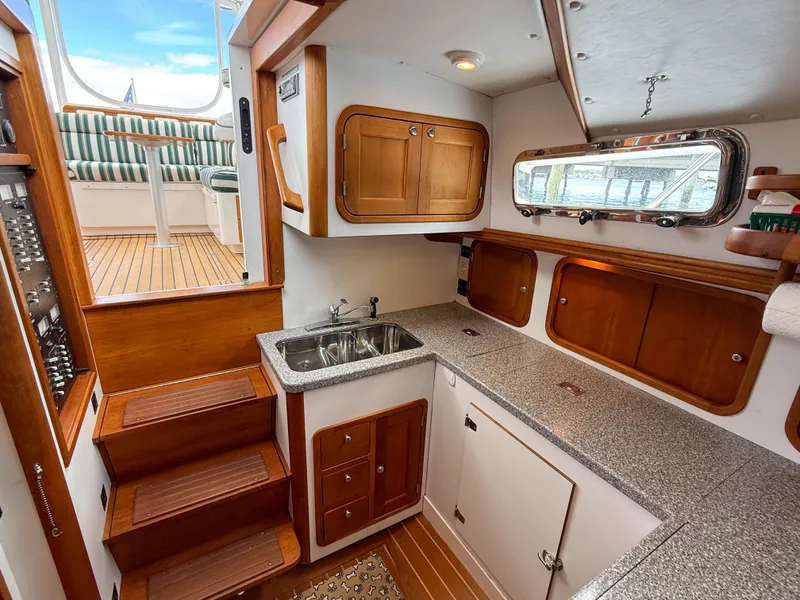 Slide: The Image of 2002 Legacy 34 Express yacht interior with wooden cabinetry and compact kitchen area. - 30