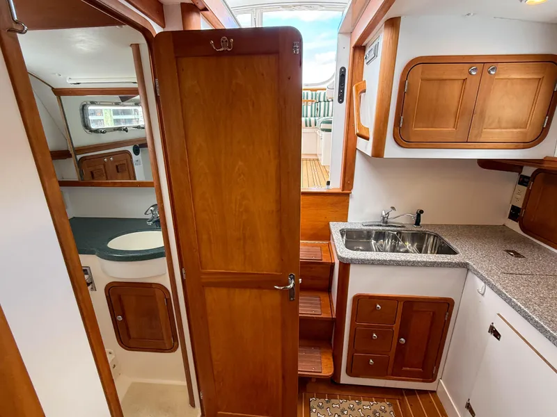 Slide: The Image of Interior of 2002 Legacy 34 Express boat with wooden cabinetry and compact kitchen area. - 37