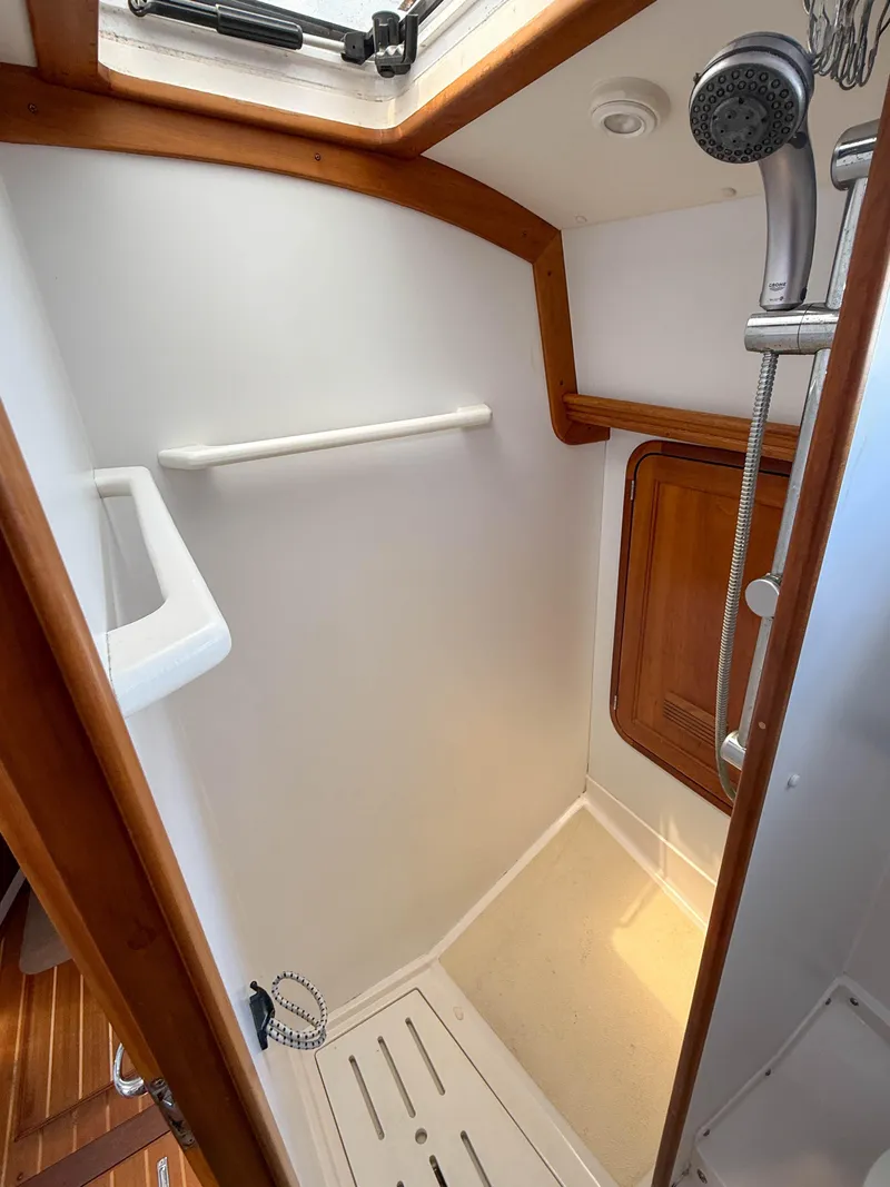 Slide: The Image of 2002 Legacy 34 Express boat shower with wooden trim and handheld showerhead. - 41