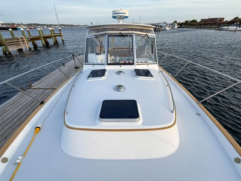 Slide: The Image of 2002 Legacy 34 Express boat docked, showcasing sleek design and spacious deck. - 45