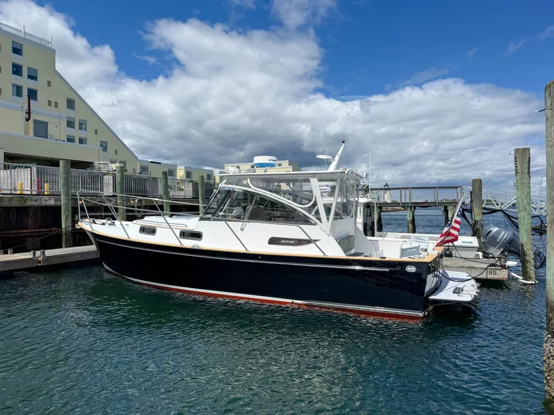 Slide: The Image of 2002 Legacy 34 Express boat docked at marina under cloudy sky. - 6