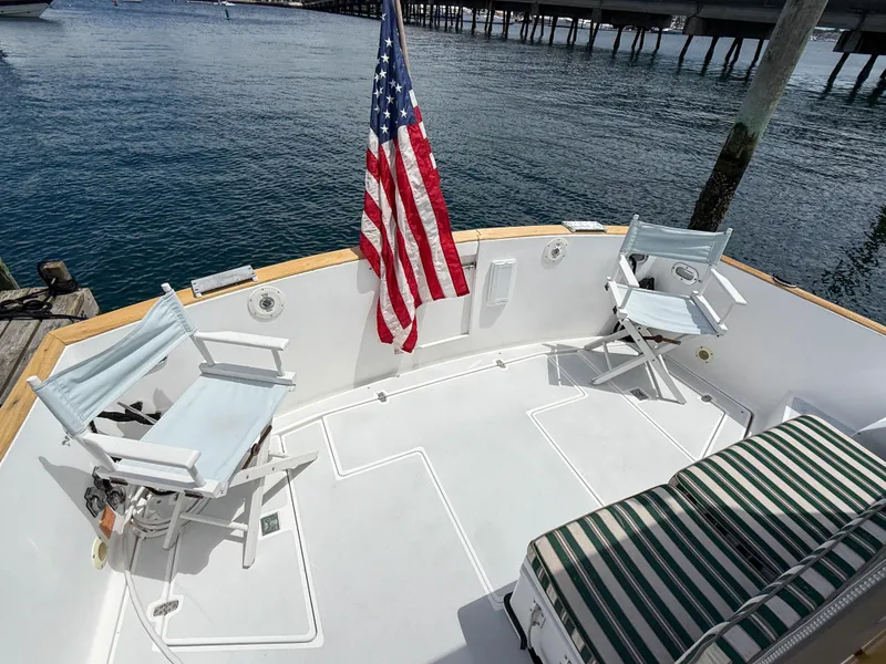 Slide: The Image of 2002 Legacy 34 Express boat deck with chairs and American flag. - 9