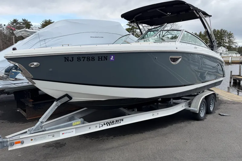 The Image of 2019 Cobalt R5 boat on trailer, parked near dock, with overcast sky. - 0