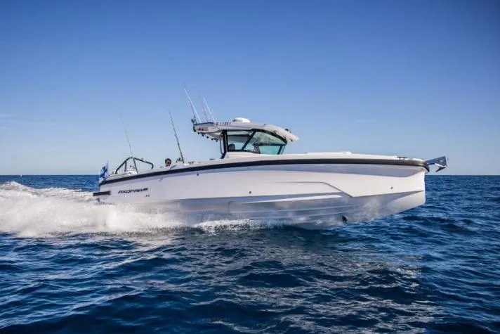 The Image of 2027 Axopar 29 CCX boat cruising on open water under clear blue sky. - 1