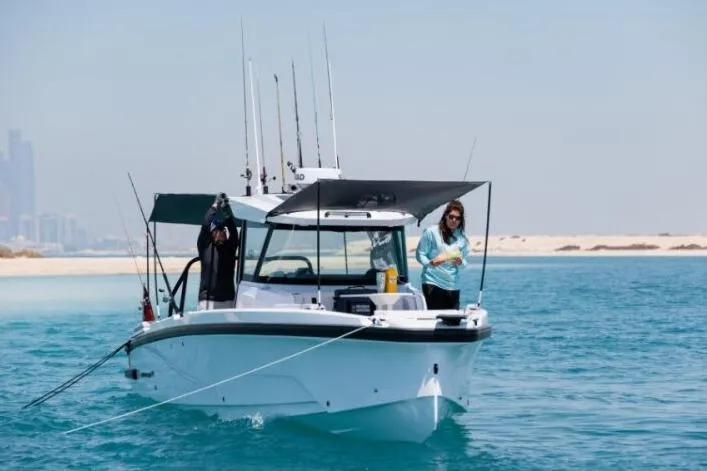 Slide: The Image of 2027 Axopar 29 CCX boat on clear blue water near sandy shore. - 4