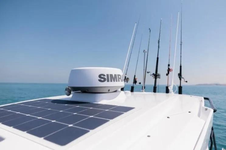 Slide: The Image of 2027 Axopar 29 CCX boat with solar panels and fishing rods on a sunny day. - 6