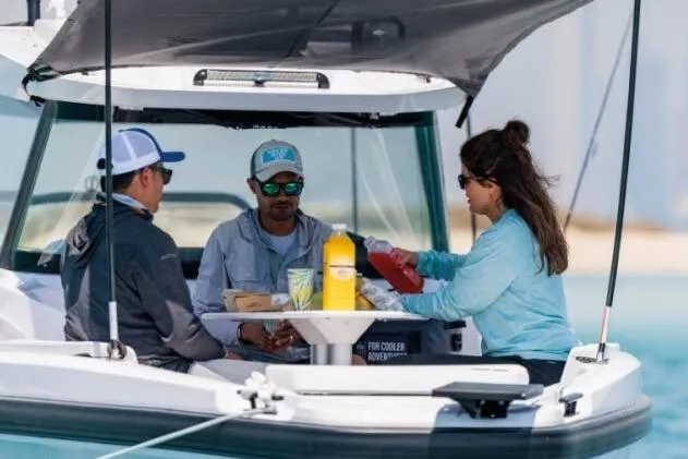 Slide: The Image of Three people enjoying a meal on a 2027 Axopar 29 CCX boat. - 7