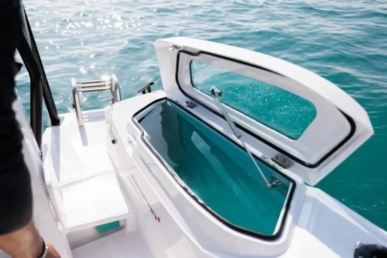 Slide: The Image of 2027 Axopar 29 CCX boat with open storage compartment on clear blue water. - 9