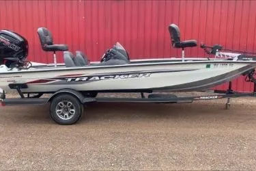 The Image of 2021 Tracker Pro Team 190 TX Tournament Edition boat on trailer, parked by red wall. - 1