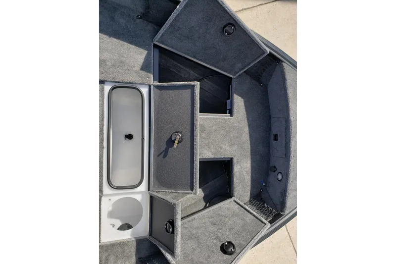 Slide: The Image of 2026 Alumacraft Classic 165 SC boat interior storage compartments, featuring carpeted surfaces and secure locks. - 16