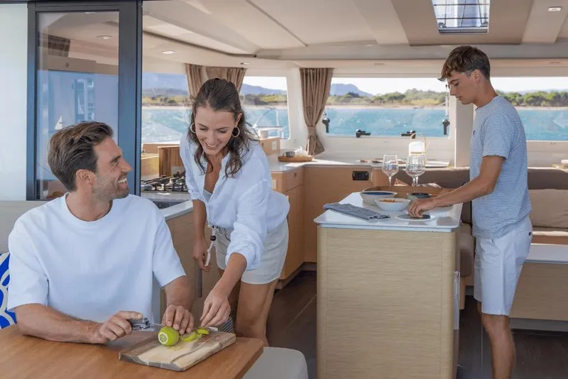 Slide: The Image of People enjoying a meal preparation inside a 2026 Fountaine Pajot 44 catamaran. - 24