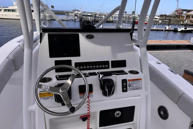Slide: The Image of 2024 Sea Fox 248 Commander boat dashboard with steering wheel and control panel at marina. - 12