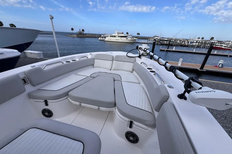 Slide: The Image of 2024 Sea Fox 248 Commander boat interior with seating, docked at marina under blue sky. - 14