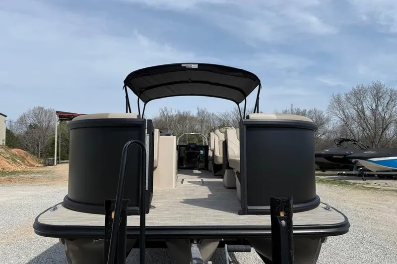 Slide: The Image of 2026 Alera 22q pontoon boat with canopy, parked outdoors on gravel. - 2