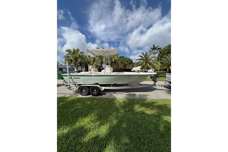 The Image of 2020 Sea Born FX22 Bay boat on trailer, parked outdoors under a blue sky. - 1