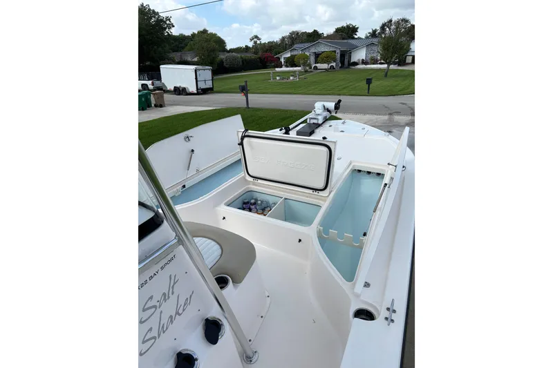 Slide: The Image of 2020 Sea Born FX22 Bay boat with open storage compartments and seating area. - 11