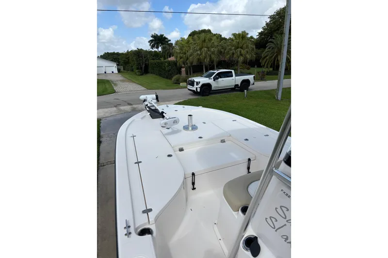 Slide: The Image of 2020 Sea Born FX22 Bay boat on driveway, with white truck and palm trees in background. - 12