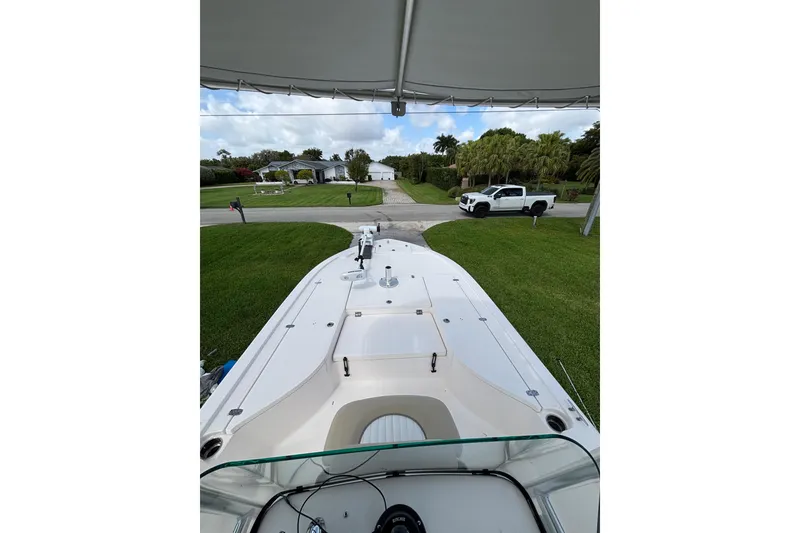 Slide: The Image of 2020 Sea Born FX22 Bay boat parked on a grassy lawn under a canopy. - 15