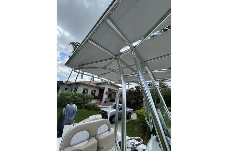 Slide: The Image of 2020 Sea Born FX22 Bay boat with T-top, parked near a house and truck. - 16